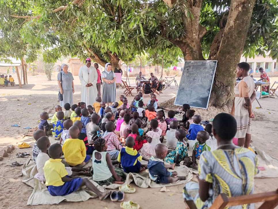 Lekcje prowadzone pod drzewem przed zbudowaniem szkoły, pierwsza od lewej siostra Elżbieta Blok – źródło: s. Elżbieta Blok