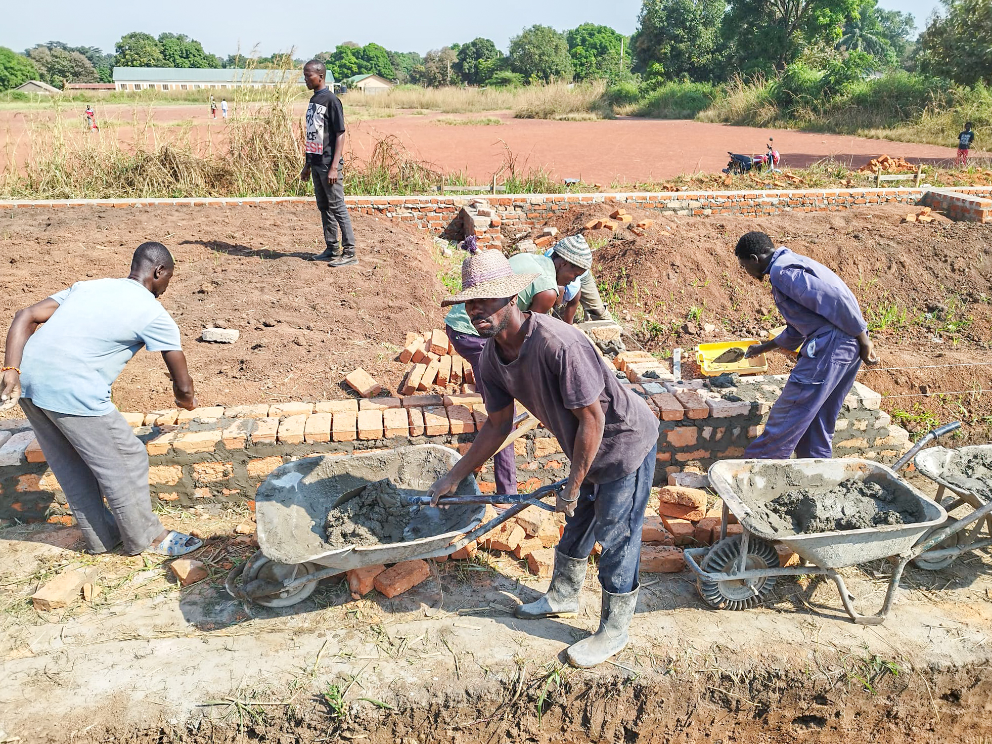 Układanie pierwszych cegieł pod szkolne ściany – źródło: s. Elżbieta Blok