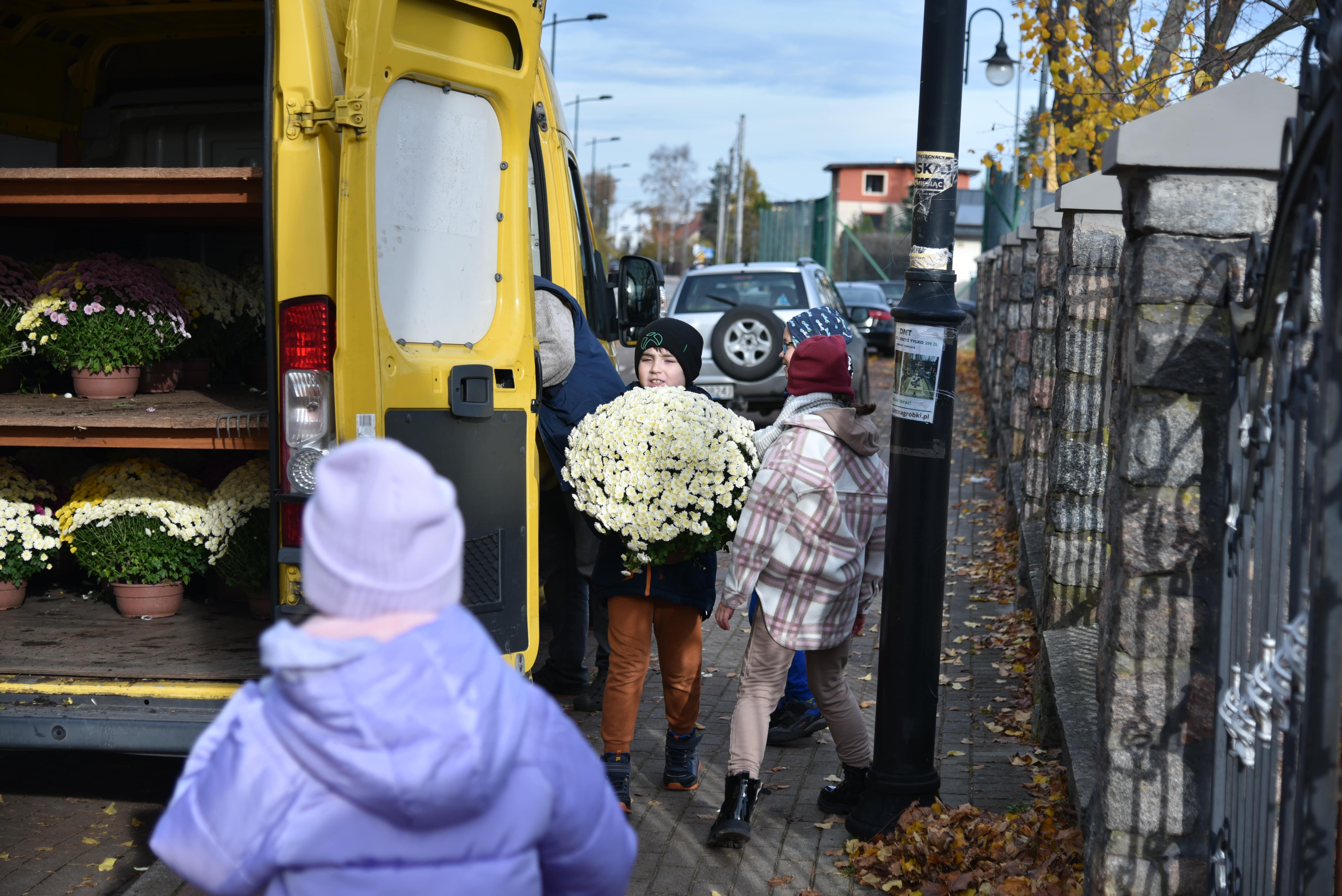 Uczniowie z kwiatami podarowanymi przez rumskich ogrodników
