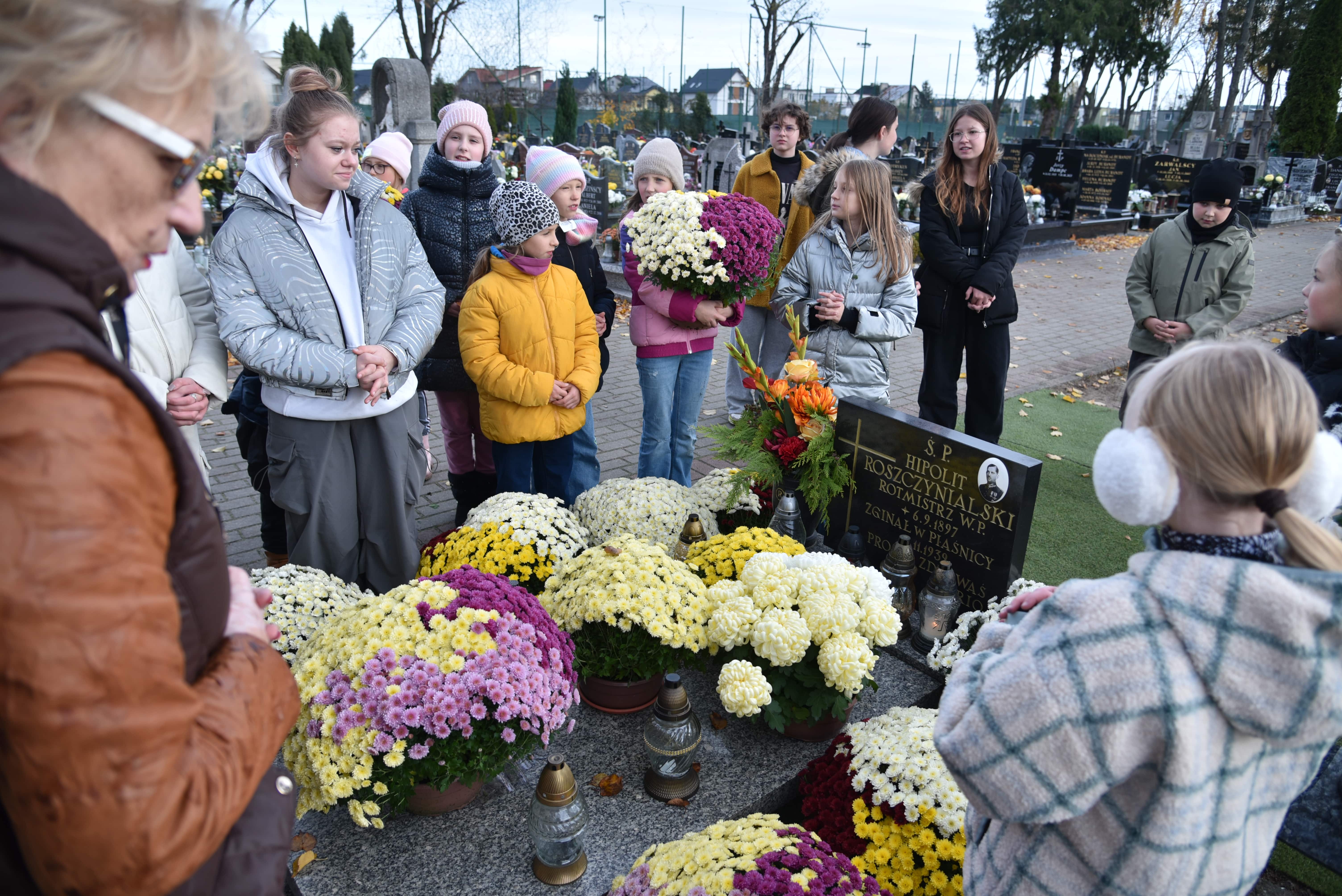 Uczniowie Jedynki z radną Teresą Hebel przy grobie Hipolita Roszczynialskiego na cmentarzu przy ul. Świętopełka