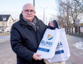 Wiceburmistrz Piotr Wittbrodt wręczający torby materiałowe mieszkańcom
