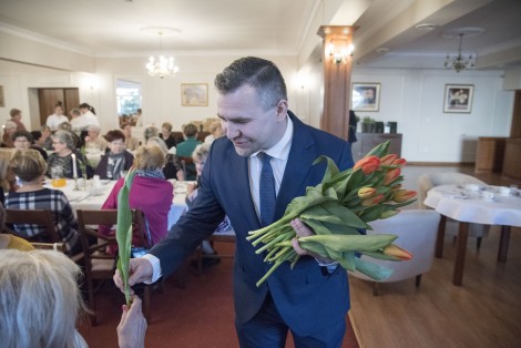 Burmistrz Michał Pasieczny wręczający kwiaty