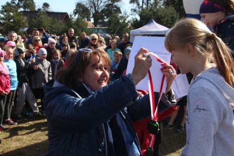 Jolanta Król wręczająca medale za udział w XX biegu