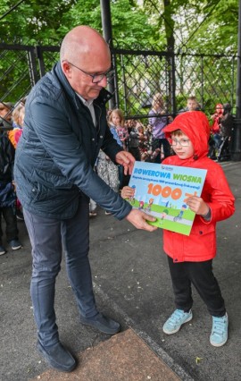 Pełnomocnik burmistrza ds. społecznych Piotr Wittbrodt wręcza nagrodę wylosowanemu uczestnikowi ze 100% frekwencją