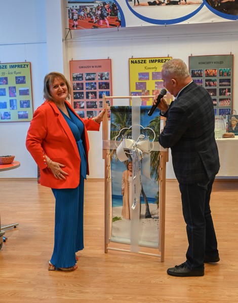 Przewodniczący rady miejskiej Krzysztof Woźniak wręcza prezent Jolancie Król