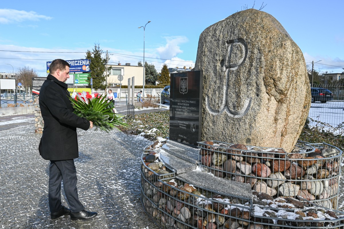 Wiceburmistrz Ariel Sinicki składający kwiaty pod pomnikiem Armii Krajowej