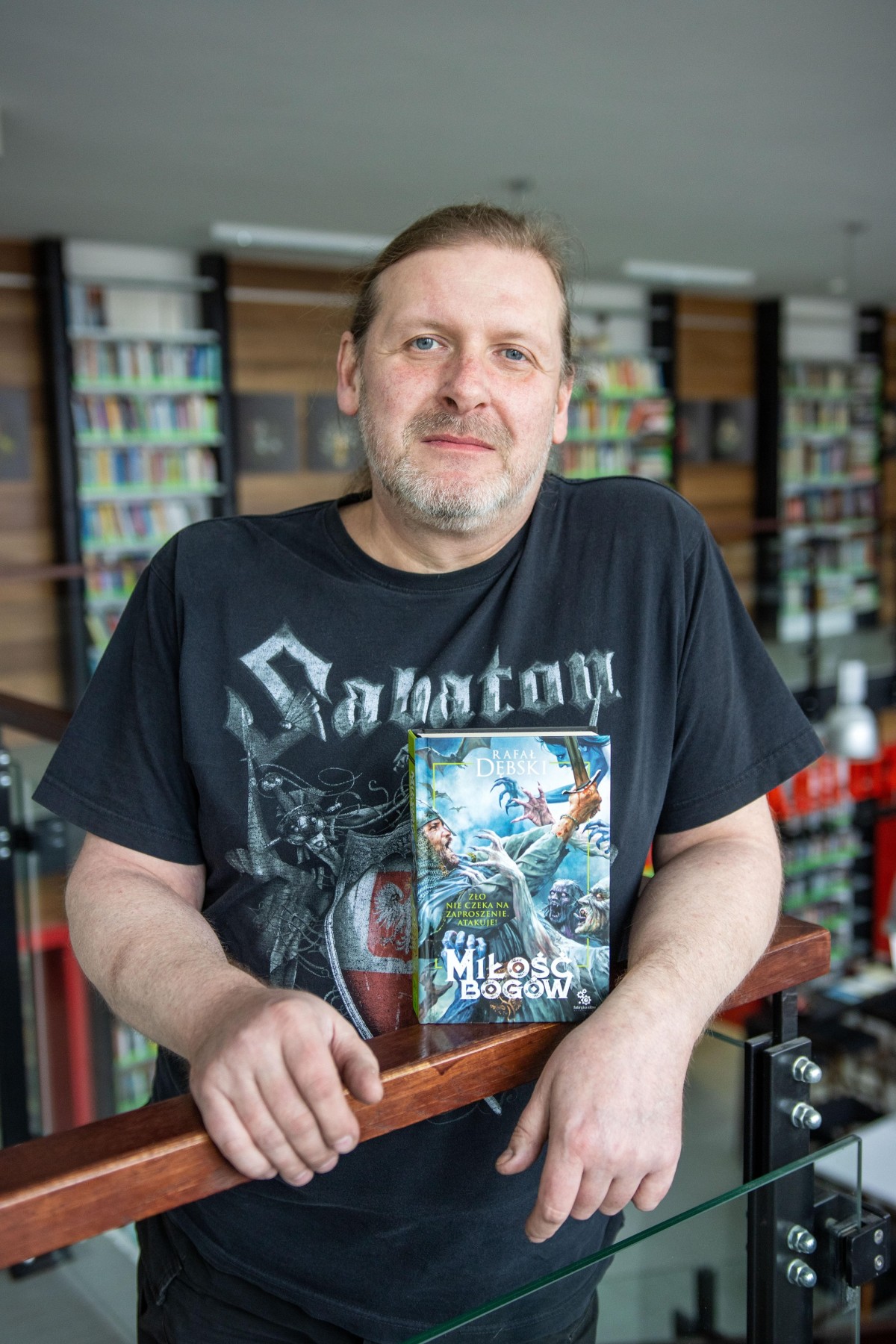 Autor Rafał Dębski prezentujący jedną z napisanych przez siebie książek
