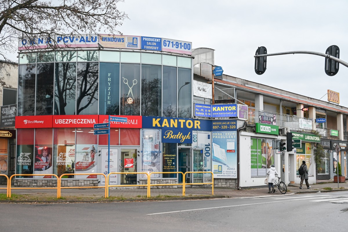 Skrzyżowanie ulic Starowiejskiej i Dąbrowskiego, gdzie znajduje się wiele szyldów i banerów reklamowych