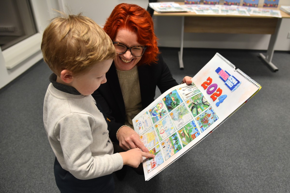 Anton Kniazhevich – zwycięzca konkursu rysunkowego dla przedszkolaków – ogląda swoją pracę wspólnie z radną Lucyną Miotk
